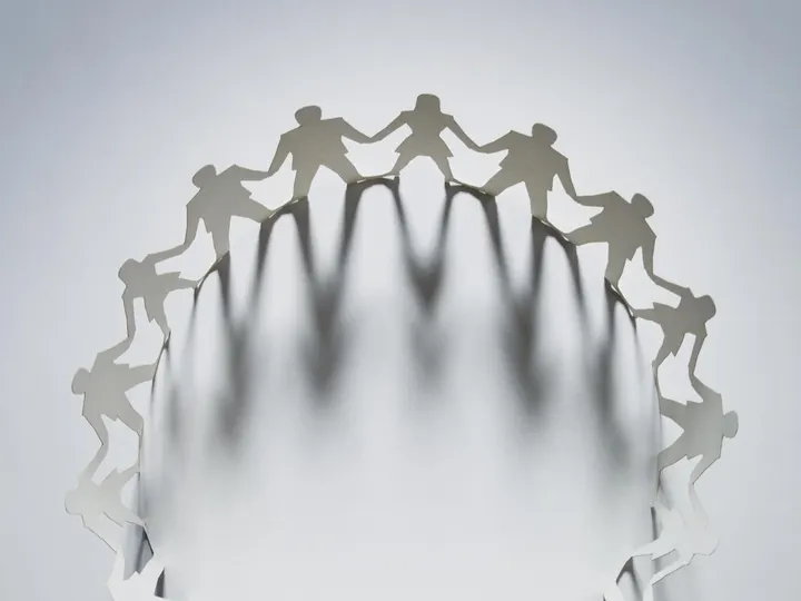 Chaîne de personnages en papier se tenant par la main